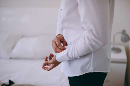 man buttoning his shirtの写真素材