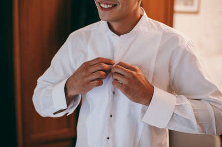 man buttoning his shirtの写真素材