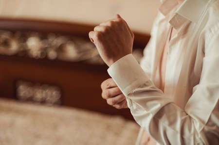 man buttoning his shirtの写真素材