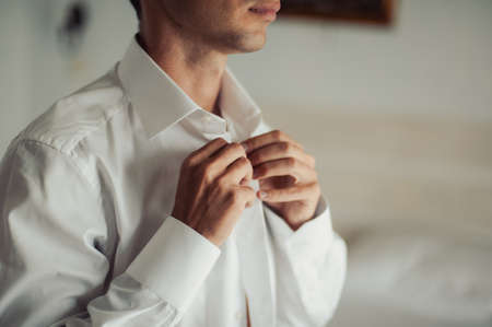 man buttoning his shirtの写真素材