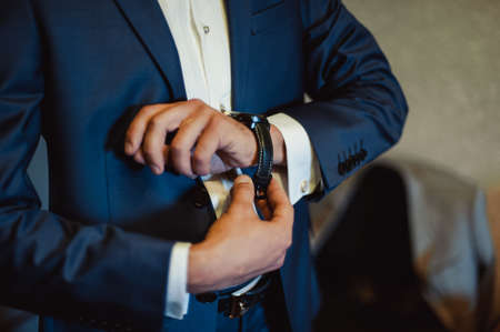 The man fastens the watch on his handの写真素材