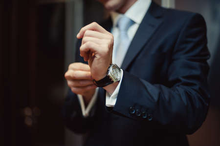 The man fastens the watch on his handの写真素材