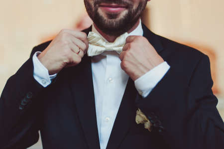 The groom puts on a butterfly. A business man dresses a butterfly.の写真素材