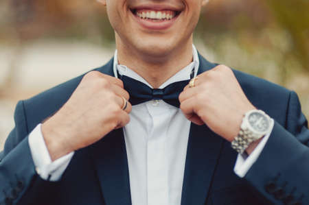 The groom puts on a butterfly. A business man dresses a butterfly.の写真素材