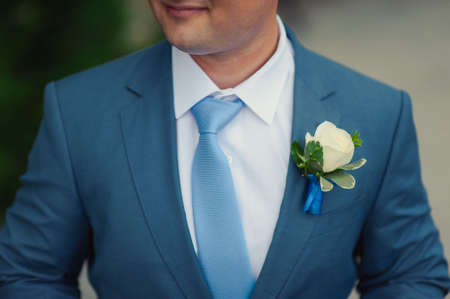 The groom puts on his tie. A business man is dressing a tie.の写真素材