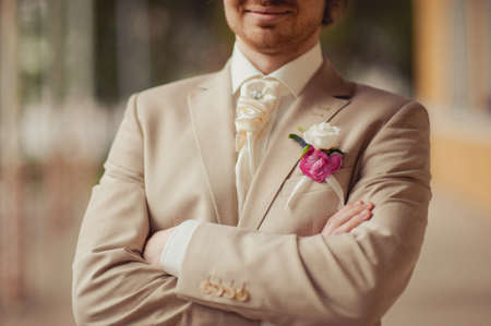 The groom puts on his tie. A business man is dressing a tie.の写真素材