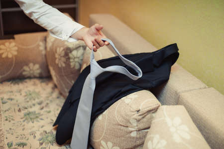 The groom puts on his tie. A business man is dressing a tie.の写真素材