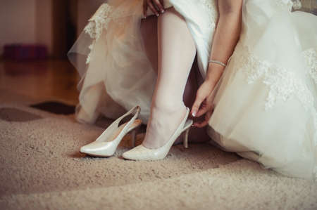 Bride Putting On Wedding Shoesの写真素材