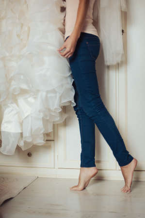 Fashionable bridesmaids dresses helped wear bow on back of wedding dress bride. Morning wedding day.の写真素材