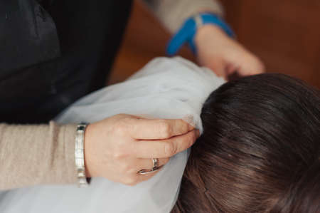The bride is wearing a veil. Beautiful long veil of white colorの写真素材