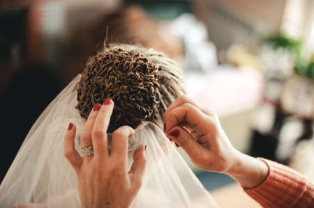 The bride is wearing a veil. Beautiful long veil of white colorの写真素材