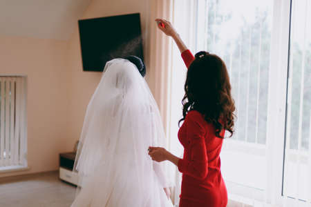 The bride is wearing a veil. Beautiful long veil of white colorの写真素材
