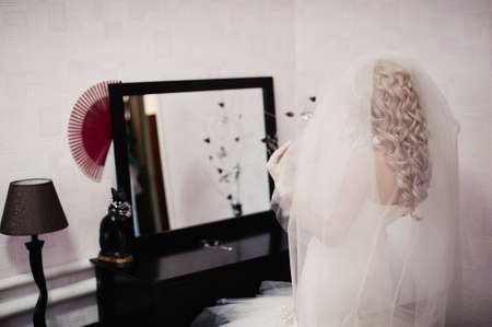 The bride is wearing a veil. Beautiful long veil of white colorの写真素材