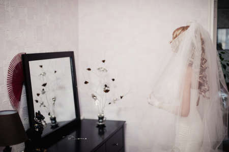 The bride is wearing a veil. Beautiful long veil of white colorの写真素材