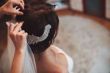 The bride is wearing a veil. Beautiful long veil of white colorの写真素材