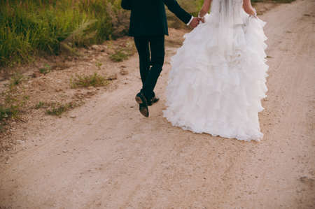 Feet of the groom and bride on the walkの写真素材