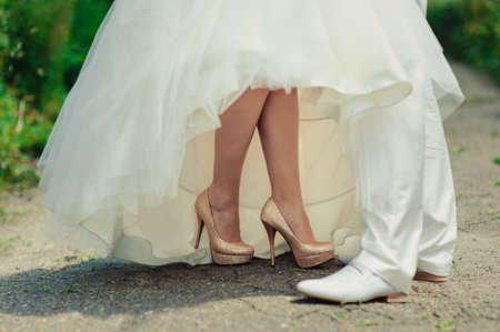 Feet of the groom and bride on the walkの写真素材