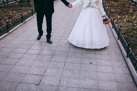 Feet of the groom and bride on the walkの写真素材