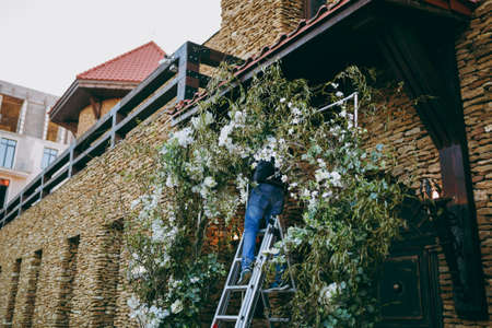 Original wedding floral decoration in the form of mini-vases and bouquets of flowers hanging from the ceilingの写真素材