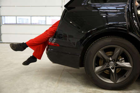 Car mechanics checking up pressure in tires at workshopの写真素材