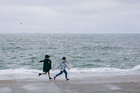 Happy, young couple is running on the beach in springの写真素材
