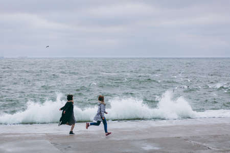 Happy, young couple is running on the beach in springの写真素材