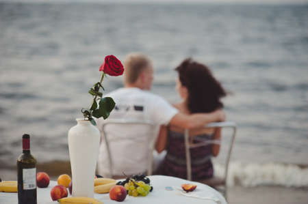 Happy couple toasting champagne sparkling wine at a relax party celebration gathering at the beachの写真素材