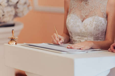 Signature Ceremony. The bride and groom sign the documents about the marriageの写真素材