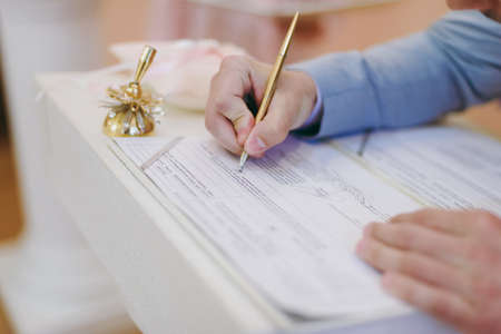 Signature Ceremony. The bride and groom sign the documents about the marriageの写真素材
