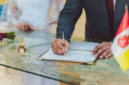 Signature Ceremony. The bride and groom sign the documents about the marriageの写真素材