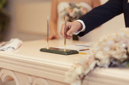 Signature Ceremony. The bride and groom sign the documents about the marriageの写真素材