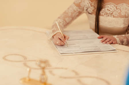Signature Ceremony. The bride and groom sign the documents about the marriageの写真素材