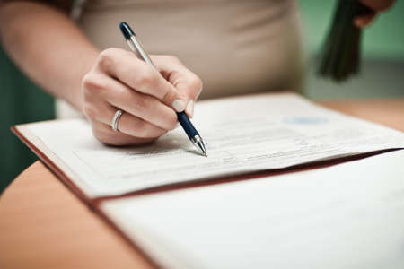 Signature Ceremony. The bride and groom sign the documents about the marriageの写真素材