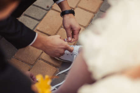 The man wears shoes. Tie the laces on the shoes. Men's style. Professions. To prepare for work, to the meeting.の写真素材