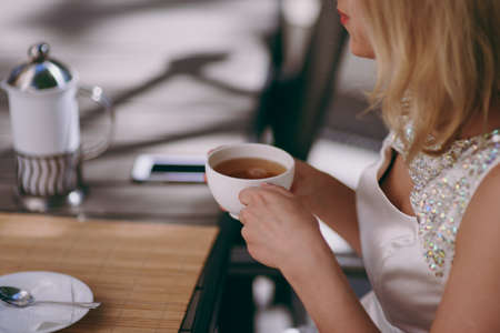 Couple drinks coffee. Closeup view of married couple holding handsの写真素材