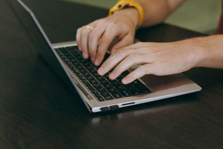 Working at home with laptop. Close-up of typing men hands on keyboard.の写真素材