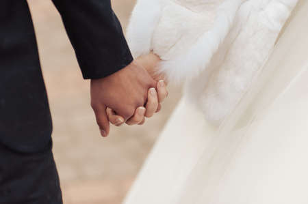 Holding hands. Closeup view of married couple holding hands