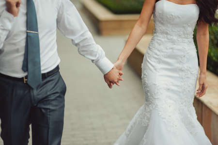 Holding hands. Closeup view of married couple holding handsの写真素材