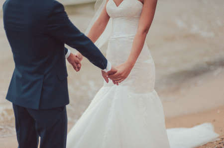 Holding hands. Closeup view of married couple holding handsの写真素材