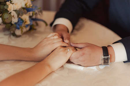 Holding hands. Closeup view of married couple holding handsの写真素材