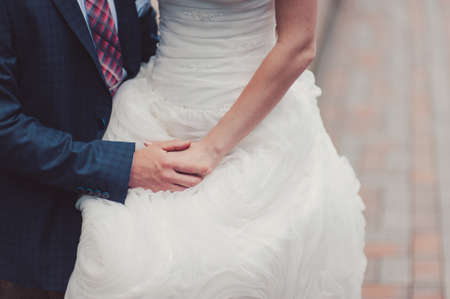 Holding hands. Closeup view of married couple holding handsの写真素材