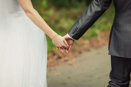 Holding hands. Closeup view of married couple holding handsの写真素材