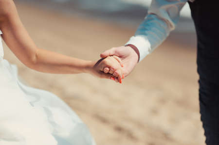 Holding hands. Closeup view of married couple holding handsの写真素材