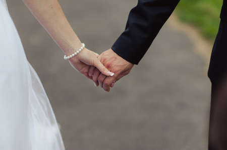 Holding hands. Closeup view of married couple holding handsの写真素材