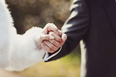 Holding hands. Closeup view of married couple holding handsの写真素材