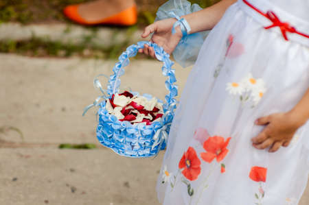 Little bridesmaid with a basket of rose petalsの写真素材