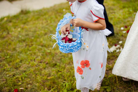 Little bridesmaid with a basket of rose petalsの写真素材