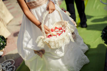 Little bridesmaid with a basket of rose petalsの写真素材