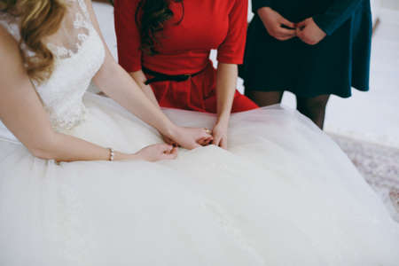 Girlfriend puts the ring on the bride's finger. The girl is showing an engagement ring on her finger. Ring on the finger of the bride. Young wife. Girl in wedding dress and with wedding ring.の写真素材