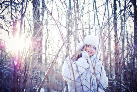 The beautiful girl in a winter snowy parkの写真素材